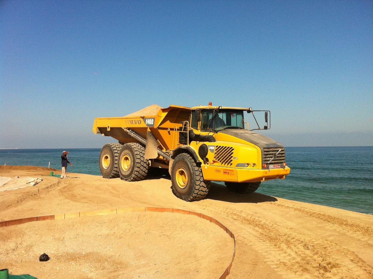 Photo of large yellow Truck filled with sand